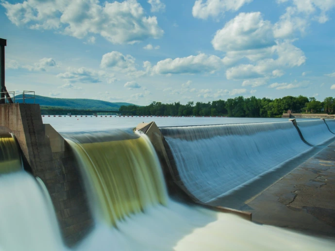 water dam under white and blue skies